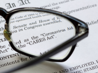 A pair of eyeglasses sitting on a document regarding the CARES act