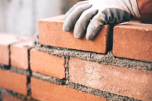 A close-up picture of bricks being laid with mortar.